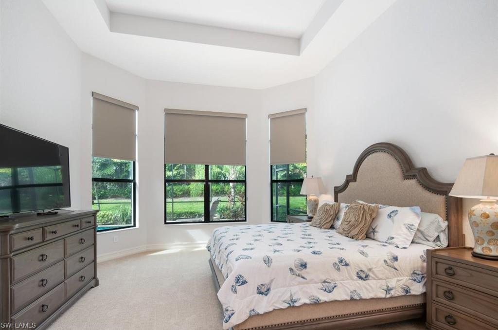 7606 Trento Circle Naples, FL 34113 - Photo 15 of 28 a bedroom with a bed and a flat tv screen on dresser