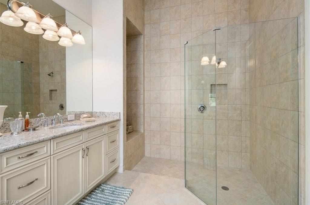 7606 Trento Circle Naples, FL 34113 - Photo 17 of 28 a bathroom with a double vanity sink and a mirror