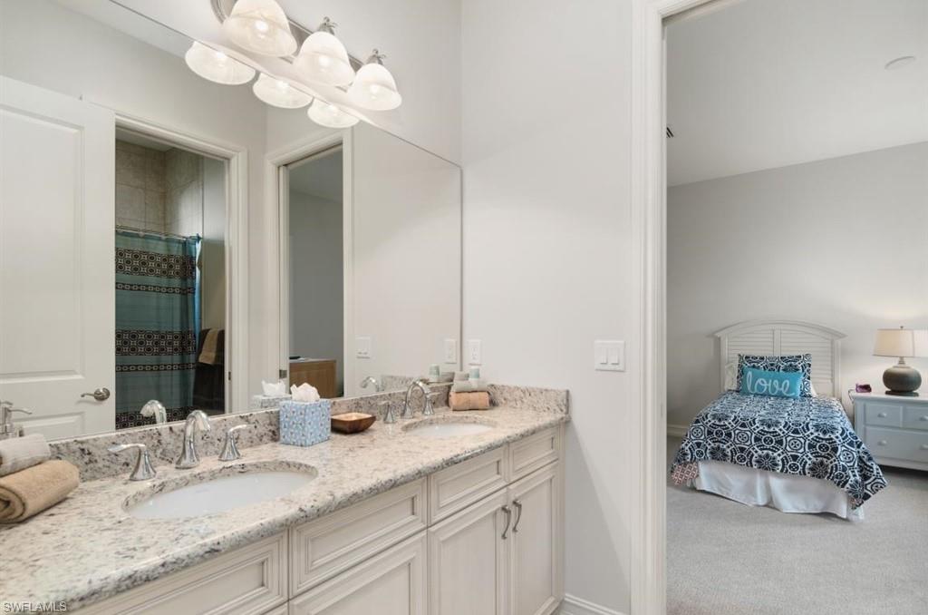 7606 Trento Circle Naples, FL 34113 - Photo 21 of 28 a bathroom with a sink vanity and a mirror