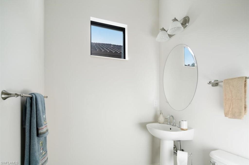 7606 Trento Circle Naples, FL 34113 - Photo 27 of 28 a bathroom with a toilet sink and mirror