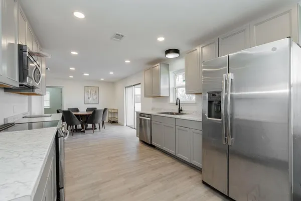 a kitchen with stainless steel appliances granite countertop a refrigerator and a stove top oven