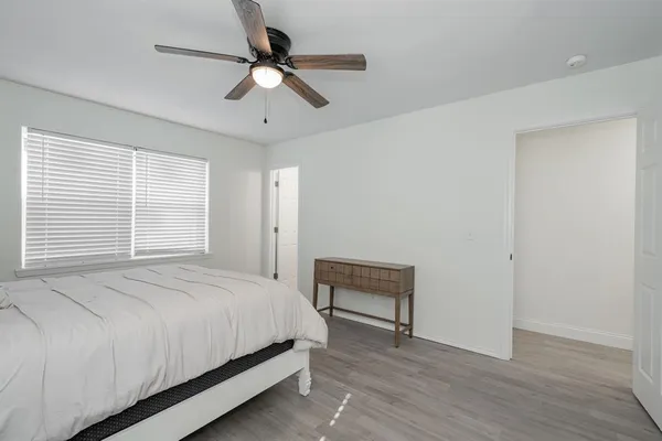 a bedroom with a bed and a ceiling fan