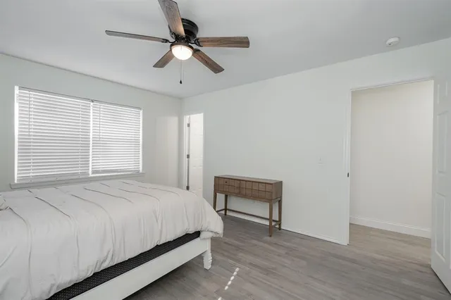 a bedroom with a bed and a ceiling fan