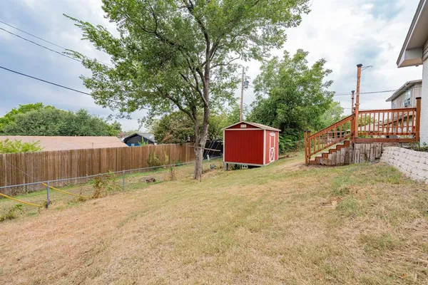 a backyard of a house with a tree and swing