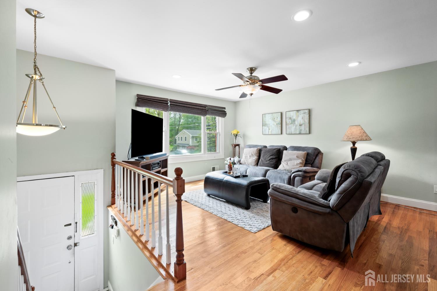 13 Fishel Road Edison, NJ 08820 - Photo 3 of 31 a living room with furniture a ceiling fan a flat screen tv and a window