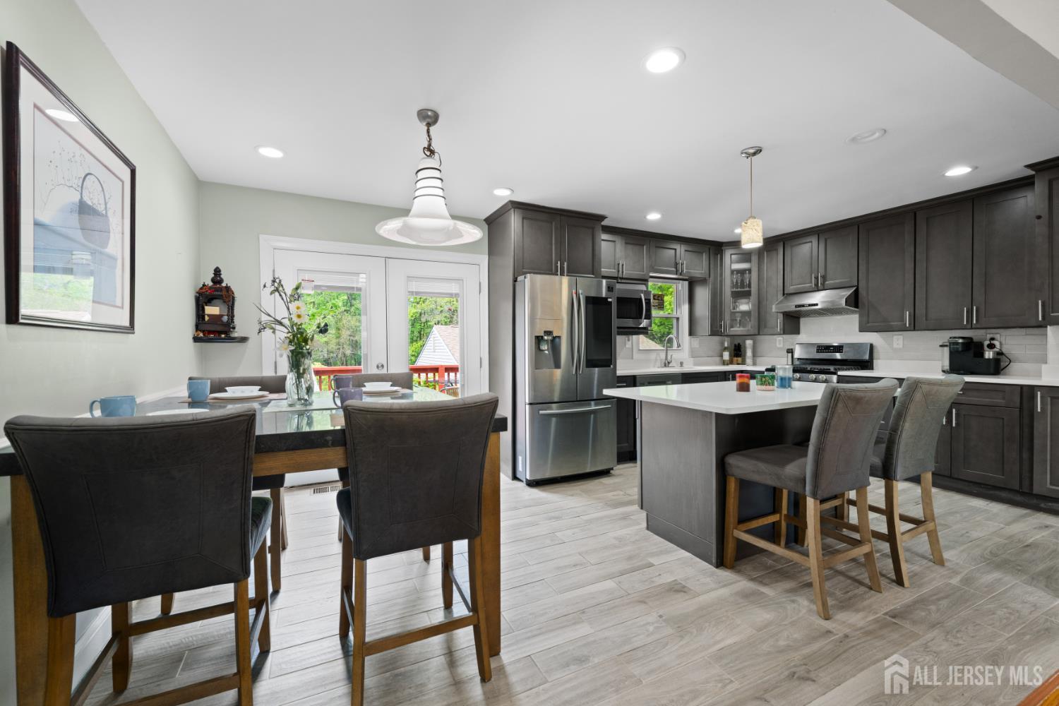 13 Fishel Road Edison, NJ 08820 - Photo 7 of 31 a kitchen with stainless steel appliances kitchen island granite countertop a dining table chairs and a refrigerator