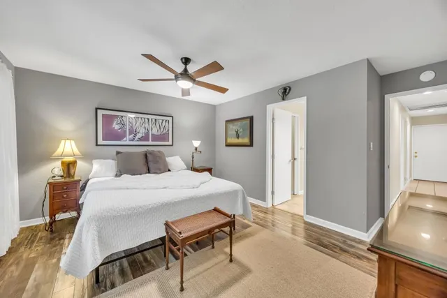 a view of a hallway with bathroom and wooden floor