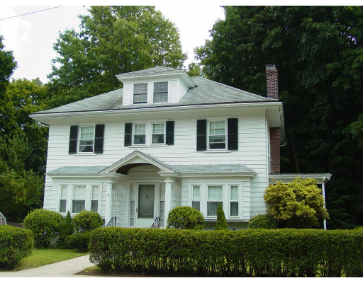 24 Midvale Road Boston, MA 02132 - Photo 1 of 1 a view of a white house with large windows and a yard with plants and trees