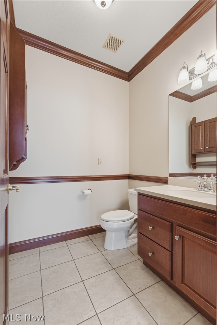 2184 Brenner Road Northeast Carrollton, OH 44615 - Photo 15 of 50 Bathroom featuring tile flooring, a wood-finish vanity with countertop, and a vanity mirror with an attached light fixture