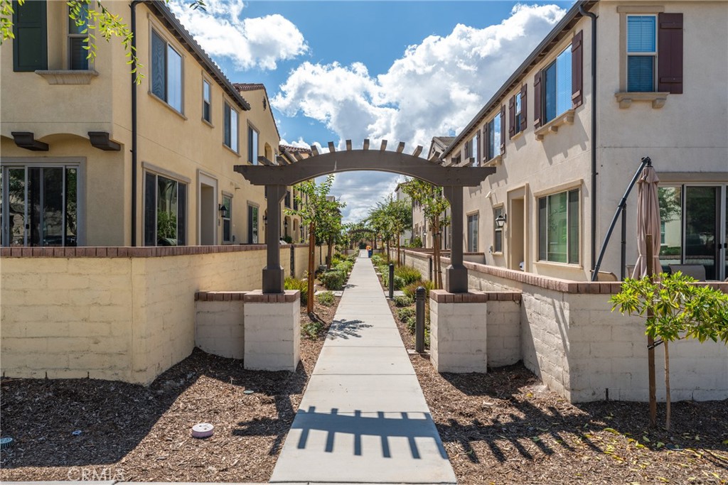 2845 East Berry Loop Privado, Unit 33 Ontario, CA 91761 - Photo 1 of 17 a view of a large building with a lot of flower plants