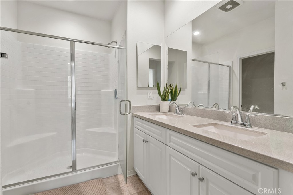 2845 East Berry Loop Privado, Unit 33 Ontario, CA 91761 - Photo 11 of 17 a bathroom with a shower sink and mirror