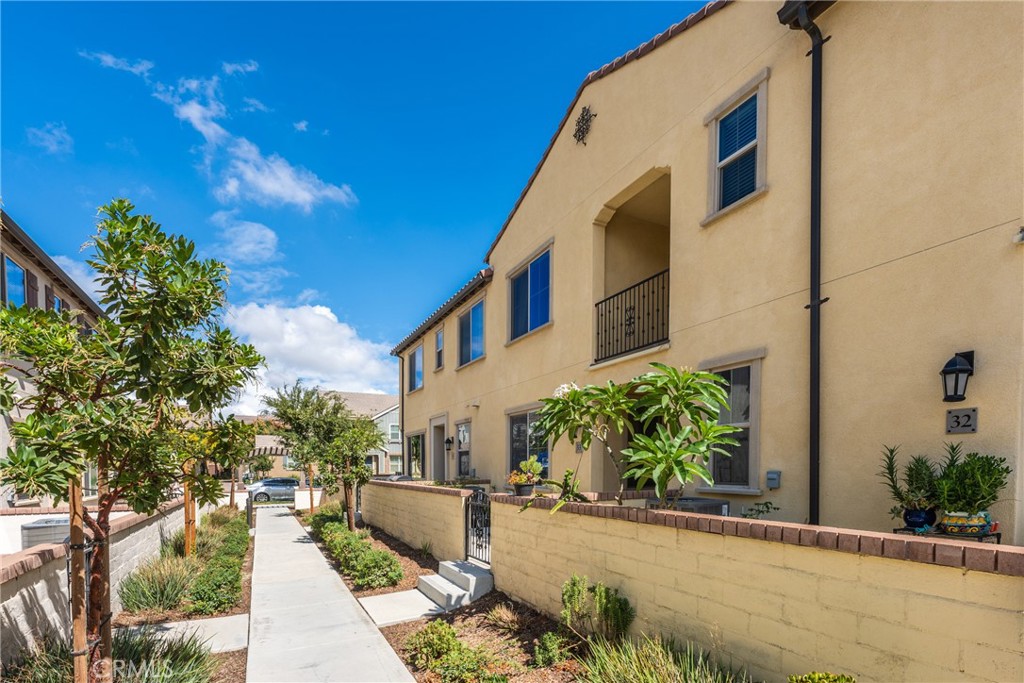 2845 East Berry Loop Privado, Unit 33 Ontario, CA 91761 - Photo 2 of 17 a front view of a house with garden