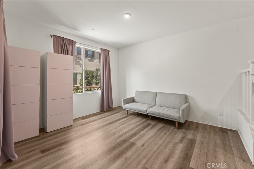 2845 East Berry Loop Privado, Unit 33 Ontario, CA 91761 - Photo 4 of 17 a living room with furniture and a wooden floor