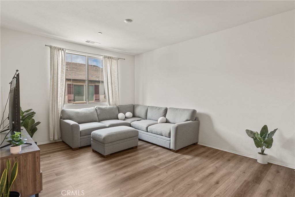2845 East Berry Loop Privado, Unit 33 Ontario, CA 91761 - Photo 7 of 17 a living room with furniture and a potted plant