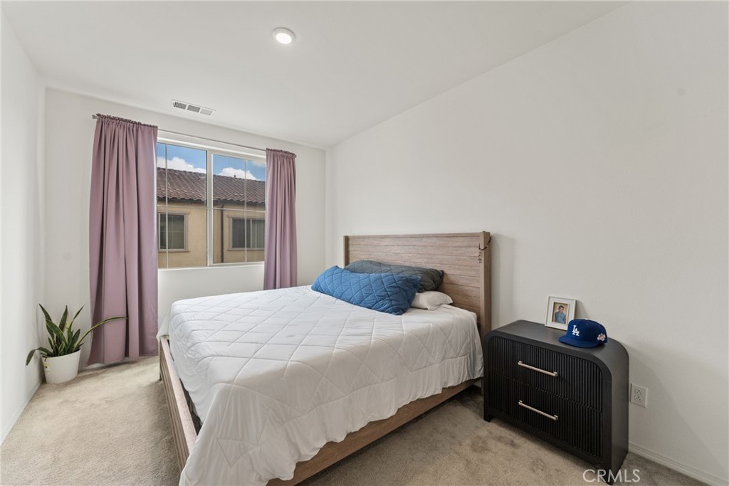 2845 East Berry Loop Privado, Unit 33 Ontario, CA 91761 - Photo 10 of 17 a bedroom with a bed and windows