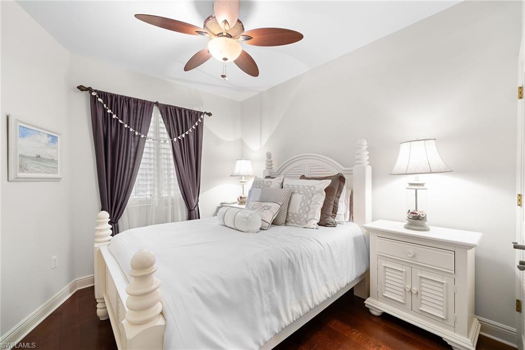 1015 Sandpiper Street, Unit D105 Naples, FL 34102 - Photo 12 of 39 a bedroom with a bed and a chandelier