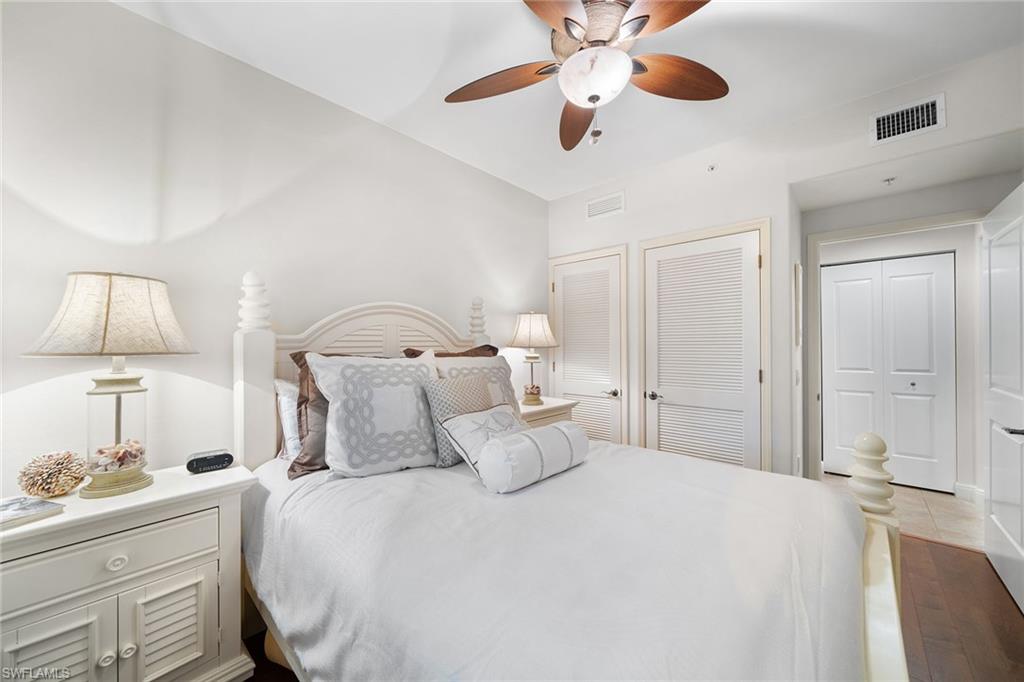 1015 Sandpiper Street, Unit D105 Naples, FL 34102 - Photo 13 of 39 a bedroom with a bed and a lamp on the dresser