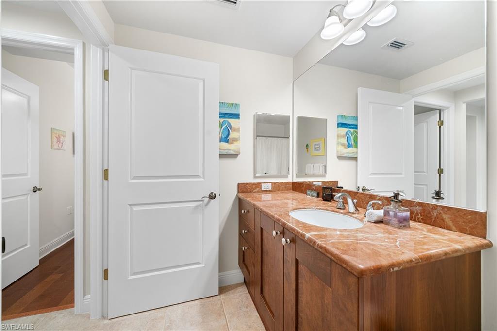 1015 Sandpiper Street, Unit D105 Naples, FL 34102 - Photo 15 of 39 a bathroom with a sink double vanity and a mirror