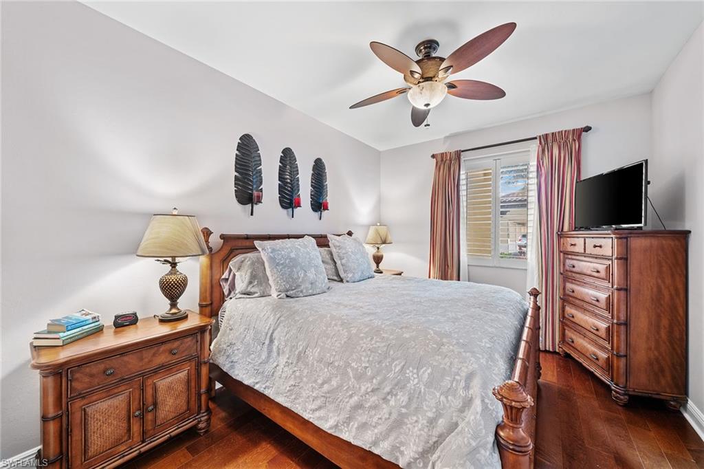 1015 Sandpiper Street, Unit D105 Naples, FL 34102 - Photo 17 of 39 a bedroom with a bed and wooden floor