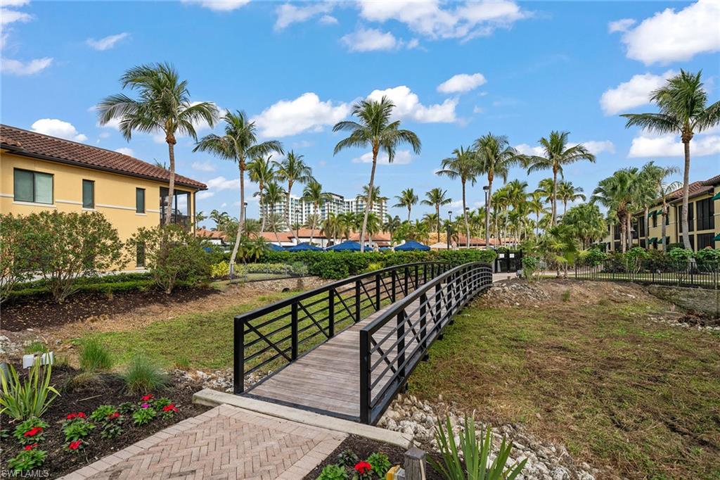 1015 Sandpiper Street, Unit D105 Naples, FL 34102 - Photo 32 of 39 a view of a house with a yard and a garden