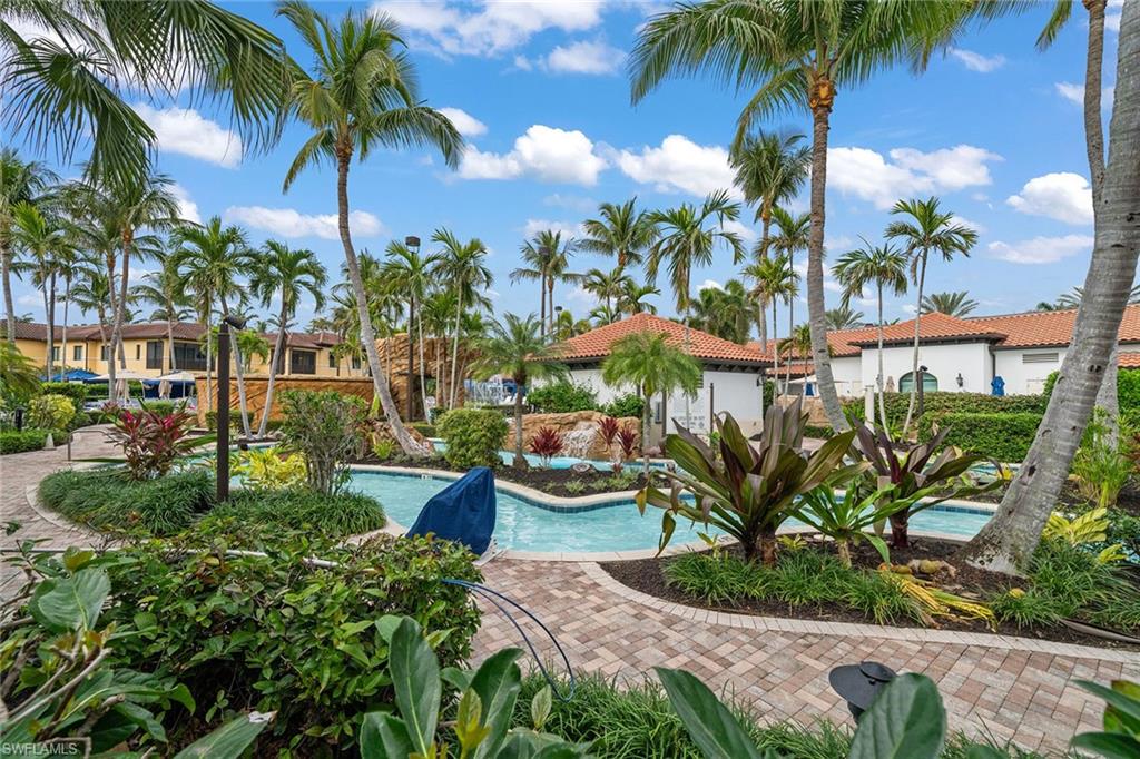 1015 Sandpiper Street, Unit D105 Naples, FL 34102 - Photo 33 of 39 a view of a backyard with potted plants and palm tree