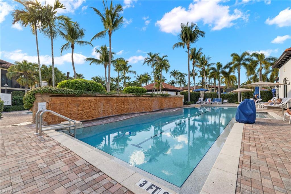 1015 Sandpiper Street, Unit D105 Naples, FL 34102 - Photo 37 of 39 a view of swimming pool with a patio and a garden