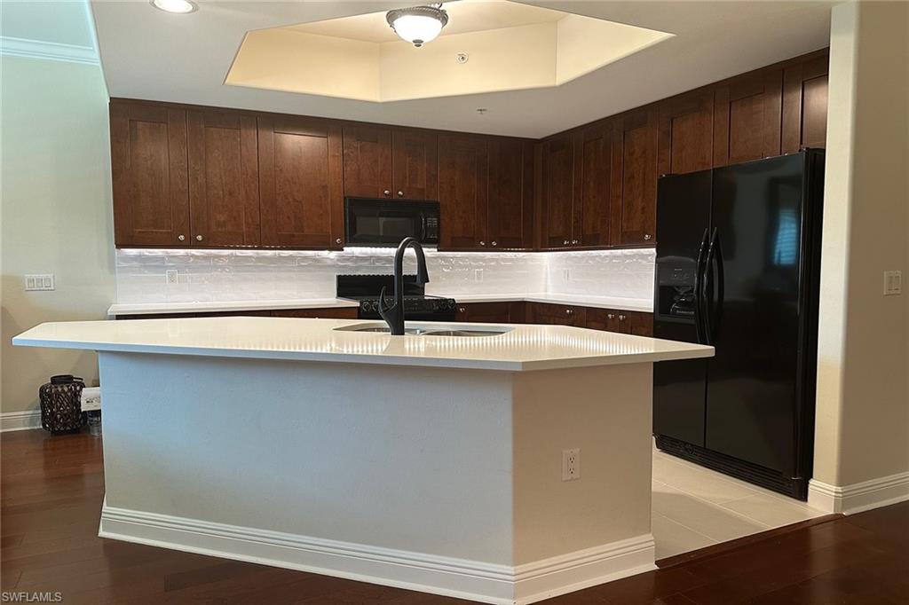 1015 Sandpiper Street, Unit D105 Naples, FL 34102 - Photo 9 of 39 a kitchen with a sink and a refrigerator