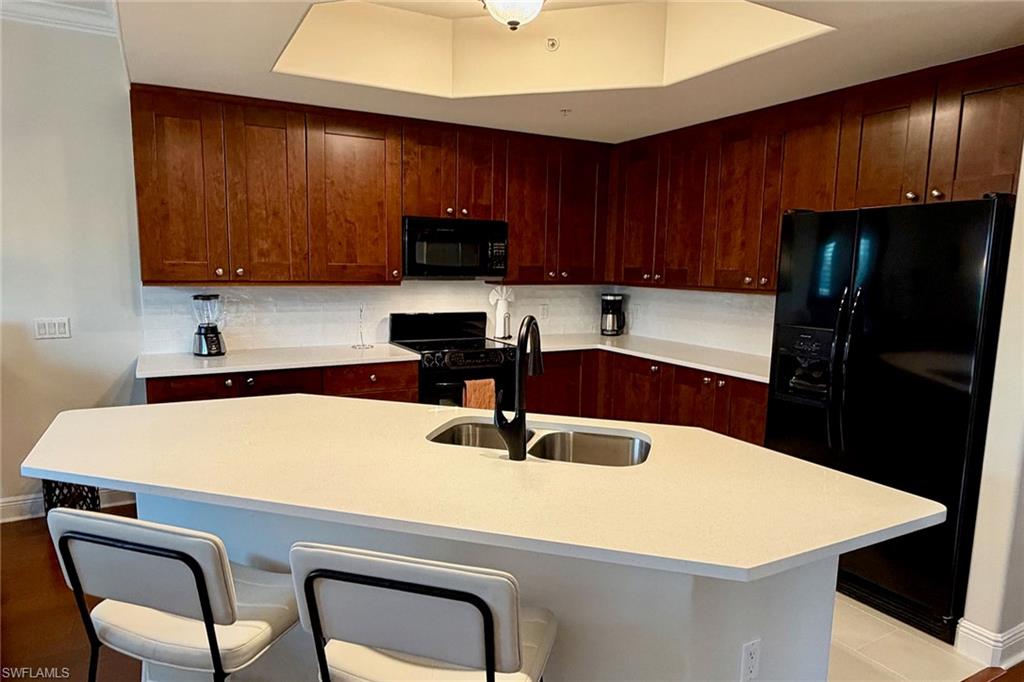 1015 Sandpiper Street, Unit D105 Naples, FL 34102 - Photo 10 of 39 a kitchen with a table chairs sink and cabinets
