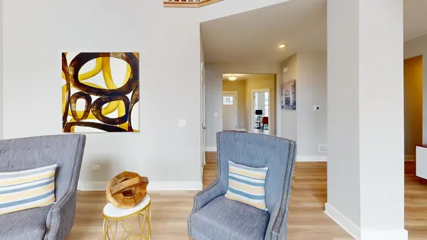 a living room with furniture and floor to ceiling windows