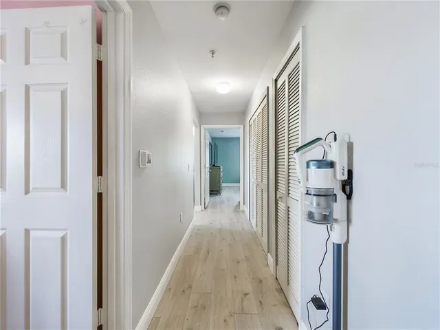 a view of a hallway with wooden floor and staircase