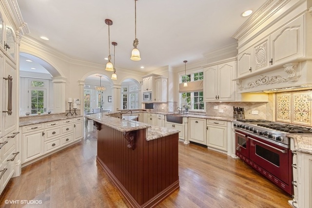 561 Walker Road Hinsdale, IL 60521 - Photo 7 of 41 a large kitchen with granite countertop a stove top oven a sink a dining table and chairs