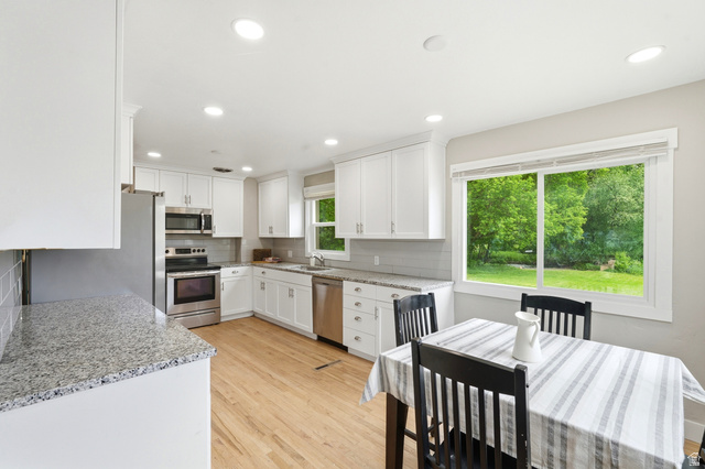 778 East 200 North Logan, UT 84321 - Photo 22 of 43 Open-concept kitchen featuring white cabinetry, light-toned wood-finish flooring, and recessed lighting