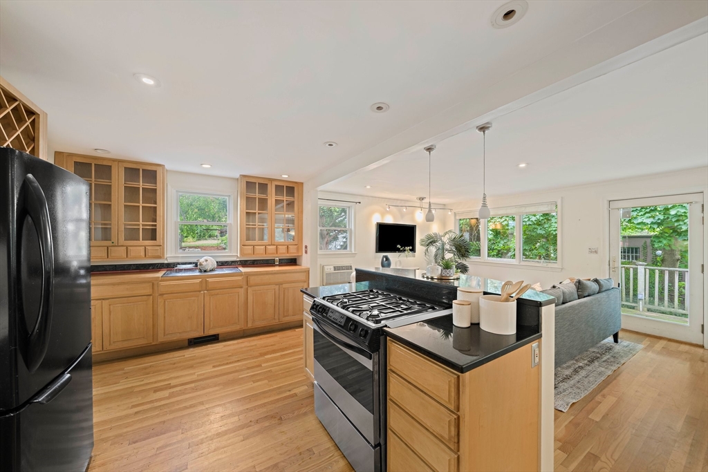 34 Wayburn Road Boston, MA 02130 - Photo 13 of 35 a kitchen that has a sink a stove top oven a refrigerator and a dining table with wooden floor