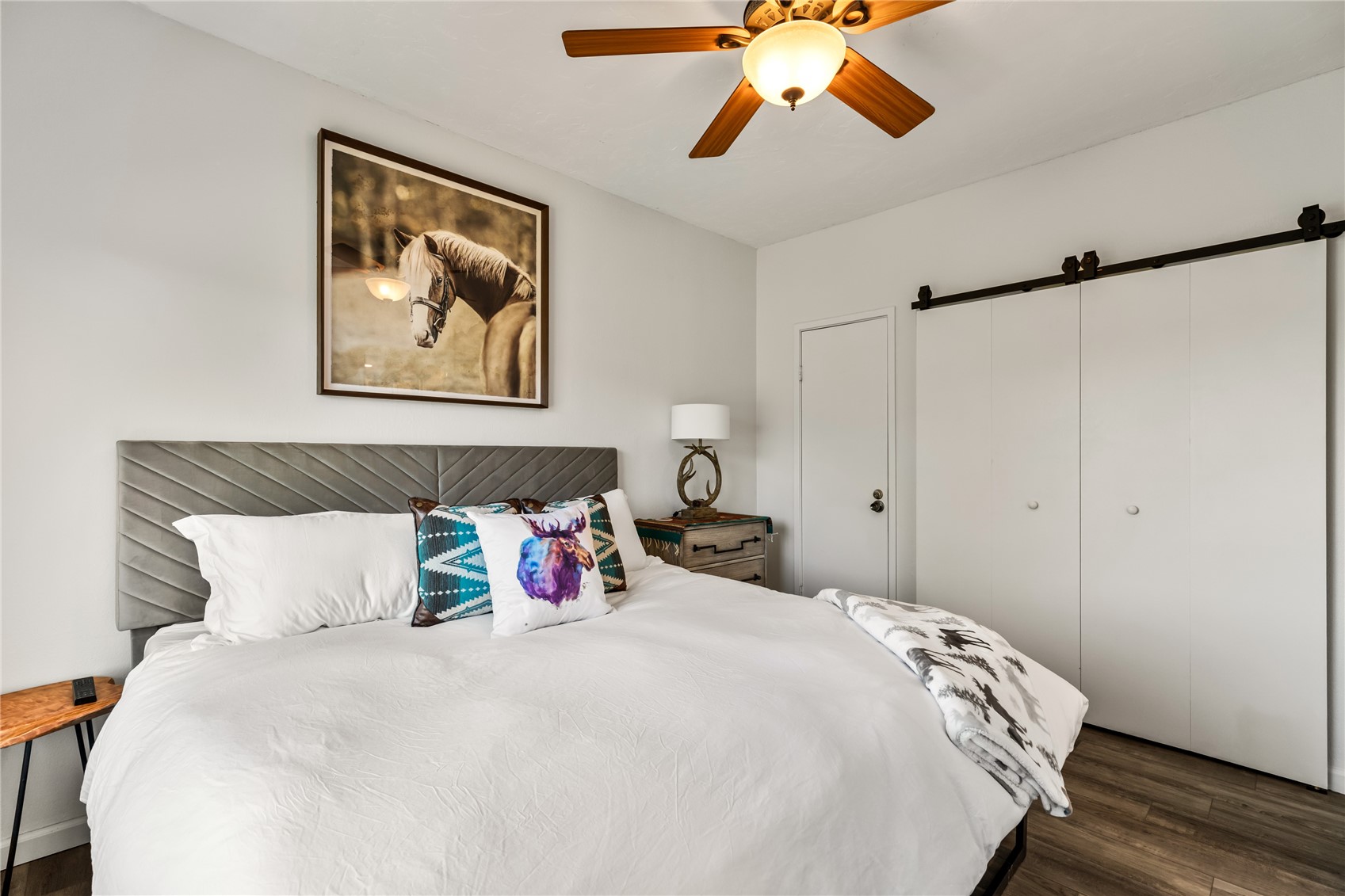 1945 Cornice Road, Unit 2224 Steamboat Springs, CO 80487 - Photo 13 of 22 Bedroom featuring ceiling fan, a closet, a barn door, and dark hardwood / wood-style flooring