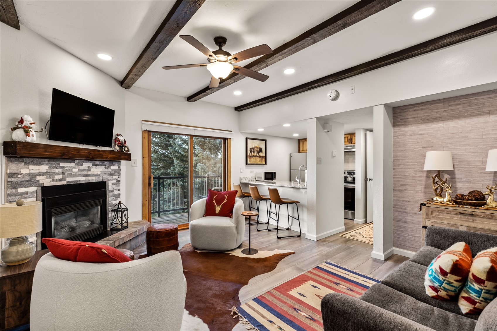 1945 Cornice Road, Unit 2224 Steamboat Springs, CO 80487 - Photo 2 of 22 Living room with wood-type flooring, ceiling fan, beamed ceiling, and a fireplace