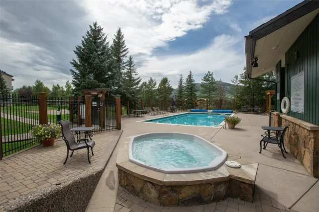 a view of a swimming pool with sitting area and garden