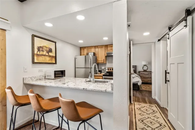 a kitchen with stainless steel appliances kitchen island granite countertop a refrigerator and a stove top oven