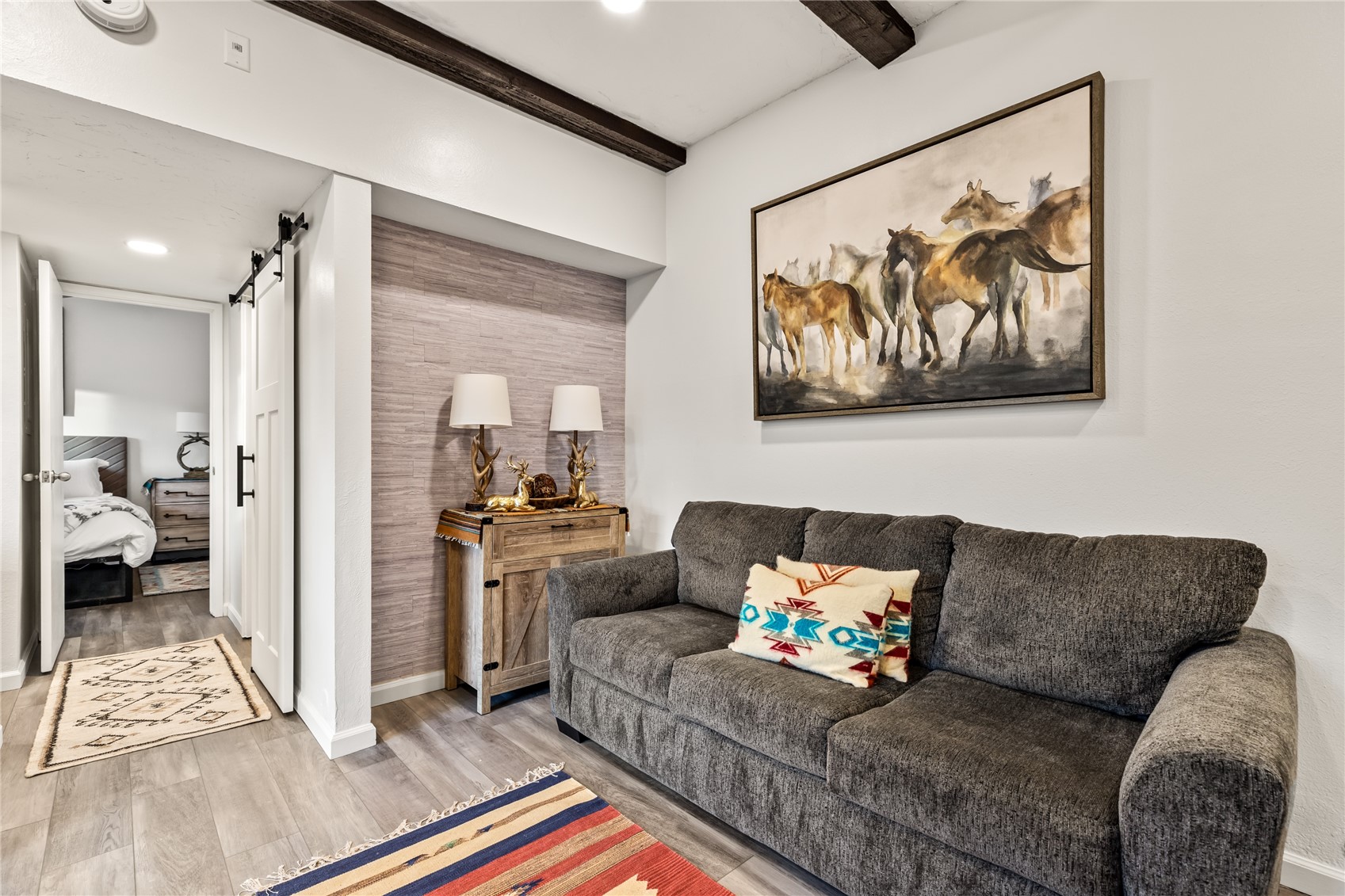 1945 Cornice Road, Unit 2224 Steamboat Springs, CO 80487 - Photo 5 of 22 Living room with a barn door, beamed ceiling, and hardwood / wood-style flooring