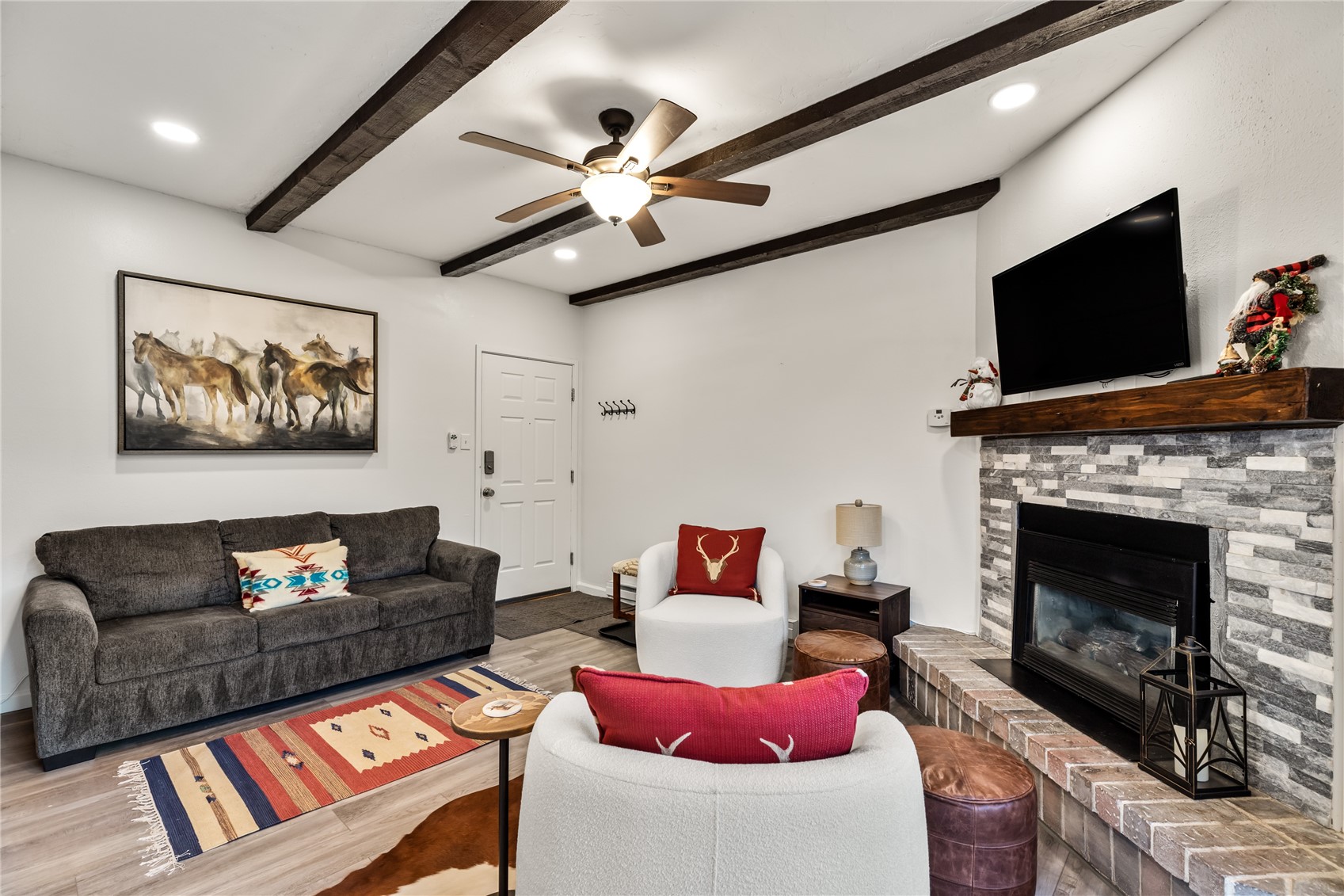 1945 Cornice Road, Unit 2224 Steamboat Springs, CO 80487 - Photo 7 of 22 Living room featuring ceiling fan, beamed ceiling, hardwood / wood-style flooring, and a fireplace