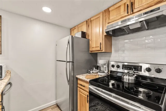 a kitchen with stainless steel appliances granite countertop a stove and a refrigerator