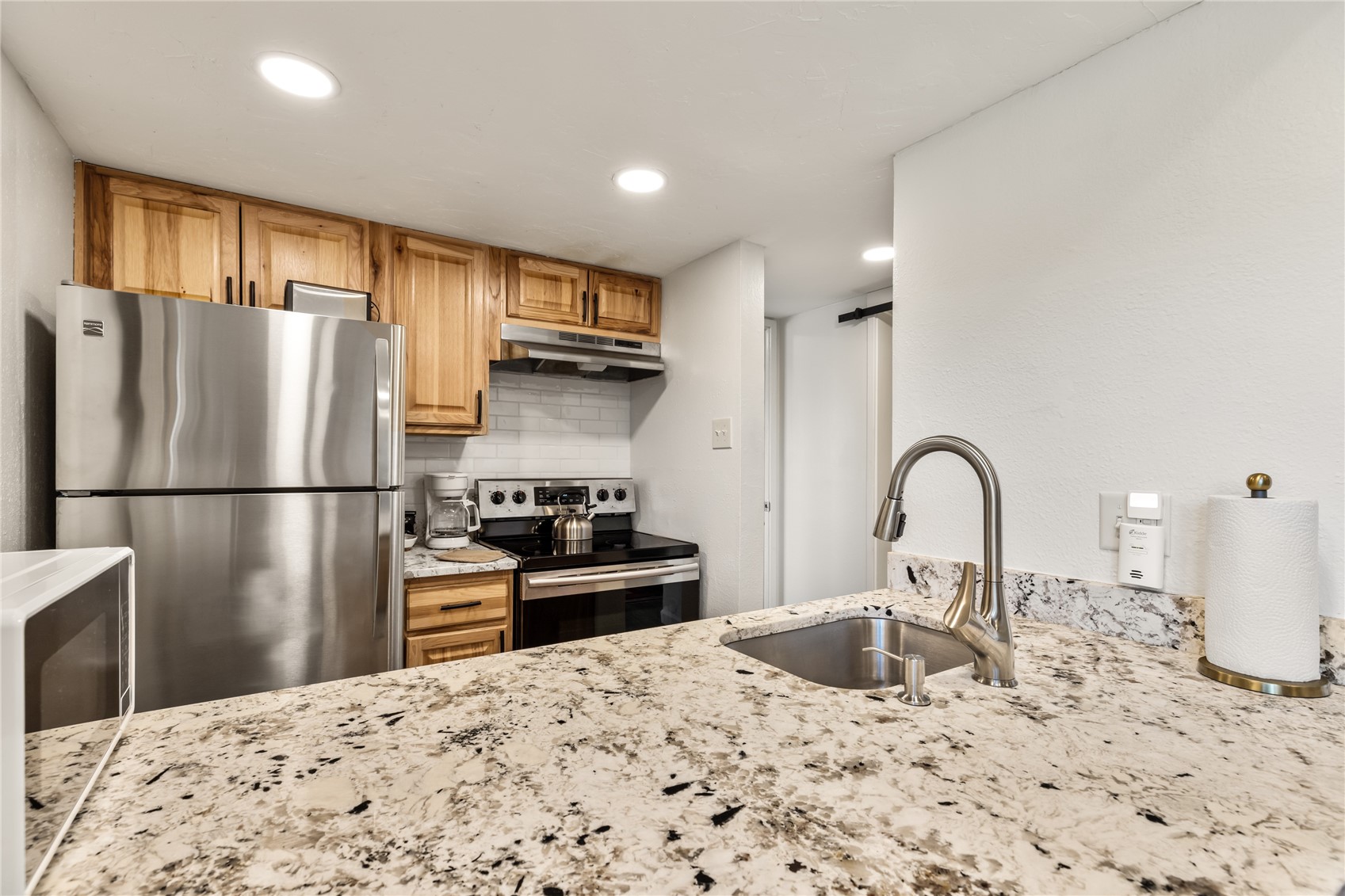 1945 Cornice Road, Unit 2224 Steamboat Springs, CO 80487 - Photo 10 of 22 Kitchen featuring light stone countertops, appliances with stainless steel finishes, backsplash, and sink