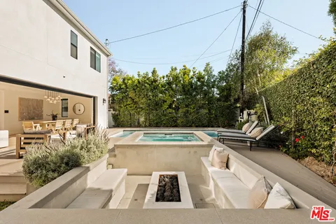 a view of a patio with couches table and chairs and potted plants