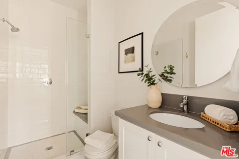 a bathroom with a granite countertop sink mirror vanity and toilet