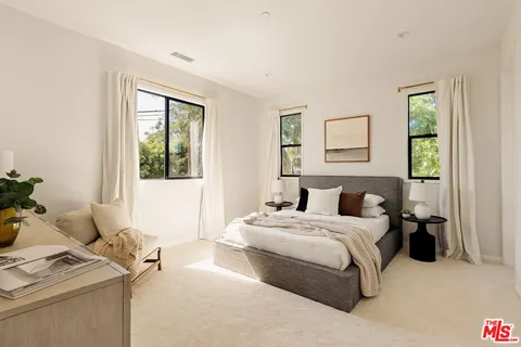 a bedroom with a bed and windows