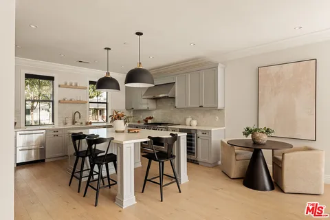 a kitchen with stainless steel appliances a sink a stove and a wooden floors