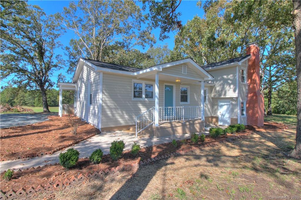 7116 Wolf Pond Road Monroe, NC 28112 - Photo 3 of 22 a front view of a house with a yard and potted plants