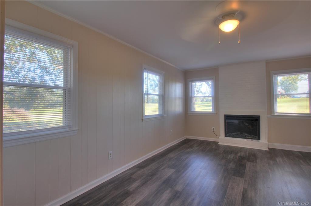 7116 Wolf Pond Road Monroe, NC 28112 - Photo 8 of 22 a view of an empty room with wooden floor and a window
