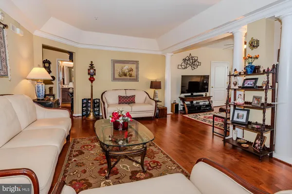 a living room with furniture a flat screen tv and a floor to ceiling window