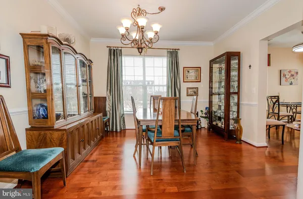 a view of a dining room with furniture wooden floor and chandelier