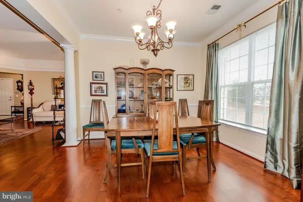 a view of a kitchen with kitchen island stainless steel appliances wooden floor and chair